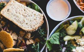 Green bowl with side of dressing and bread